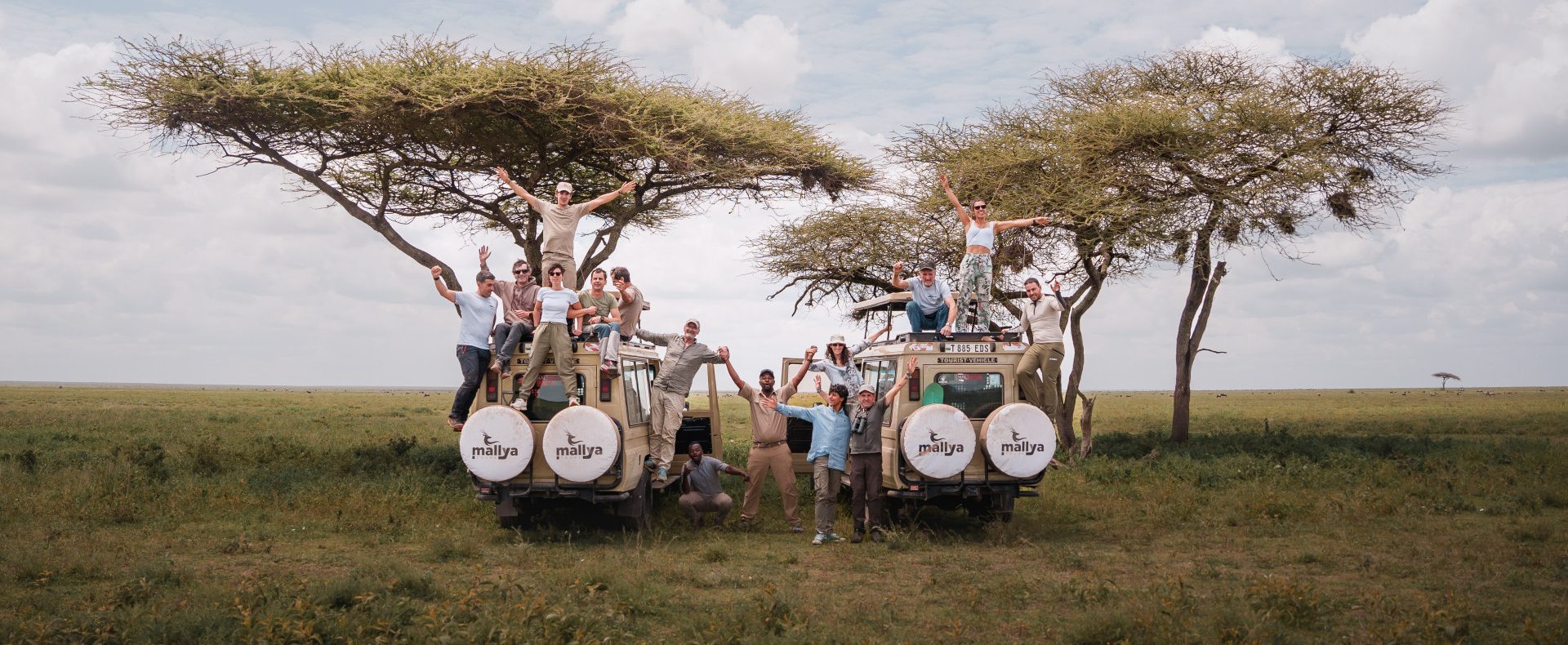Group of Tourists in a 4x4 Safari jeep taking a picture at Serengeti National Park-Mallya Tours